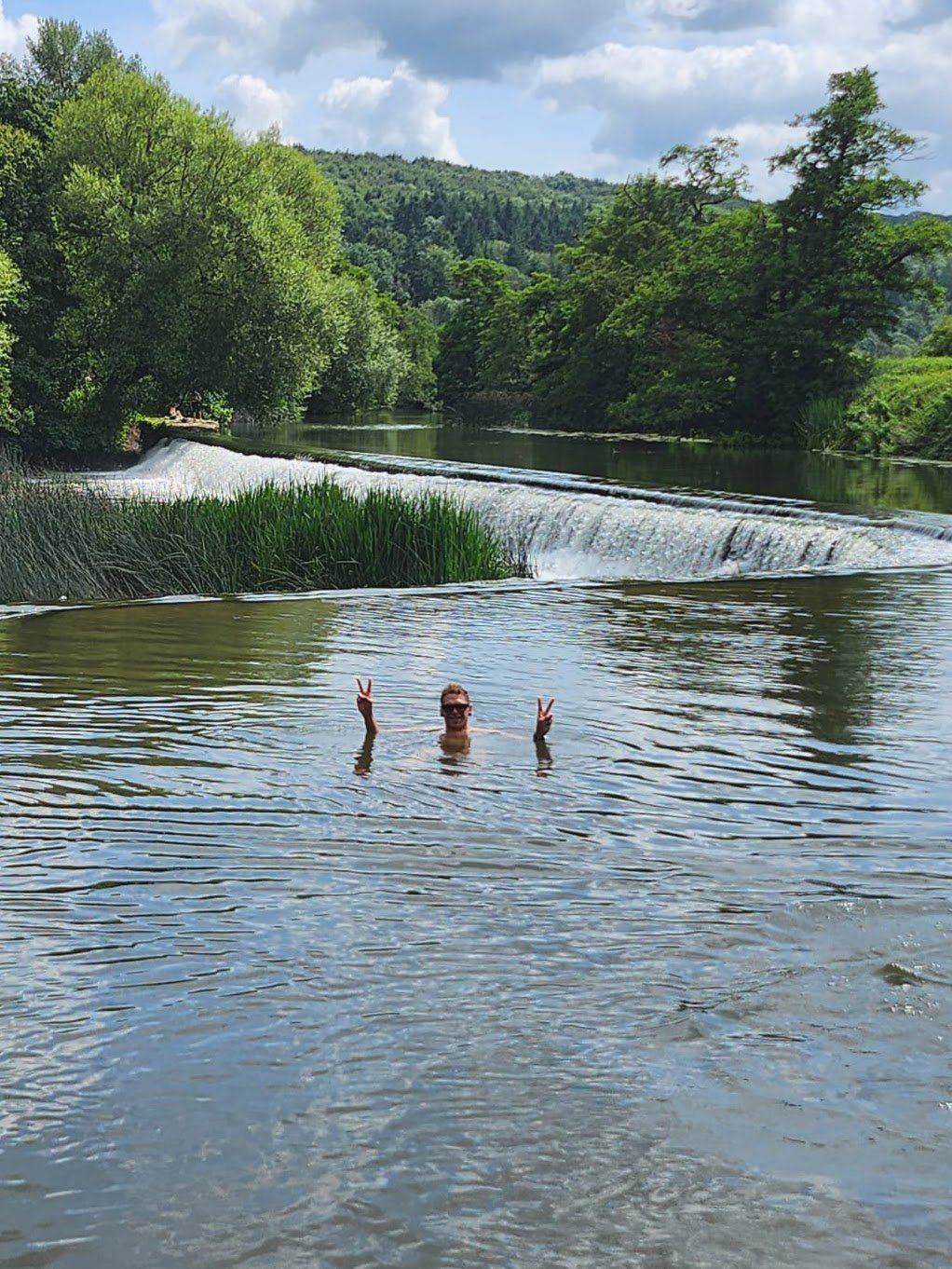 A wild swim by a river weir